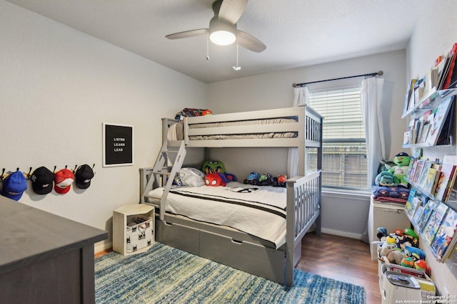 bedroom with wood finished floors, a ceiling fan, and baseboards
