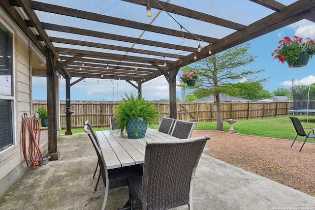 view of patio / terrace with a pergola, a trampoline, outdoor dining area, and a fenced backyard