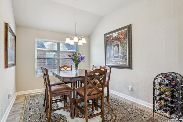 dining space featuring baseboards, lofted ceiling, a notable chandelier, and light wood-type flooring