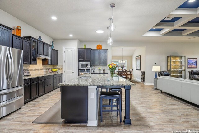 kitchen with recessed lighting, light wood-style flooring, stainless steel appliances, and a sink