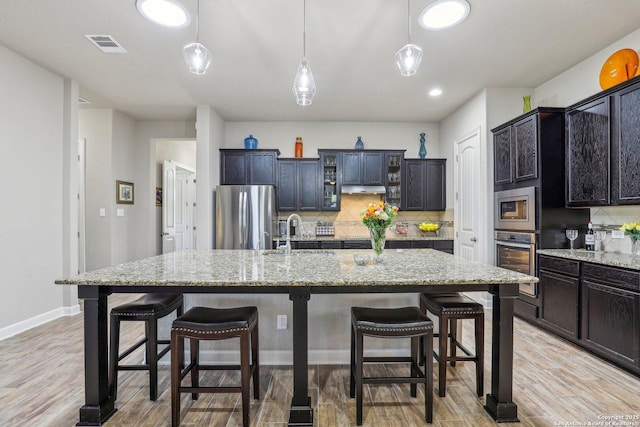 kitchen with visible vents, a sink, backsplash, and appliances with stainless steel finishes