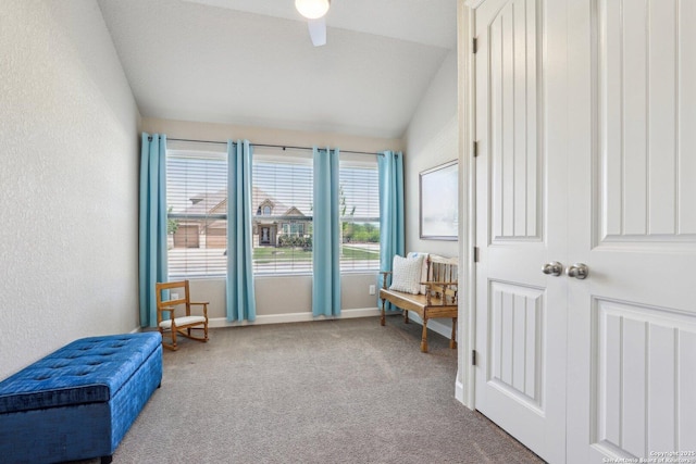 sitting room featuring vaulted ceiling, a textured wall, baseboards, carpet flooring, and ceiling fan