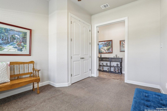 corridor featuring carpet floors, visible vents, and baseboards