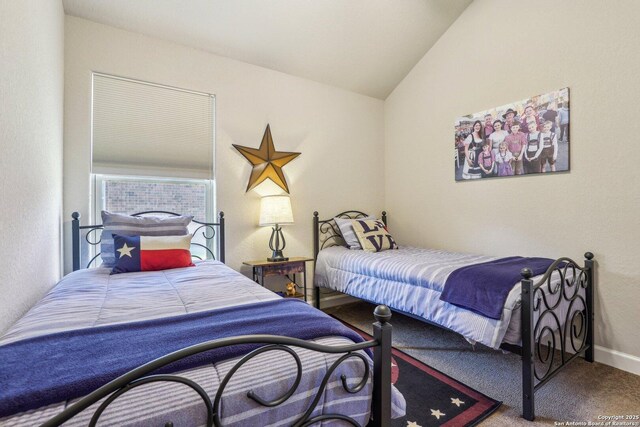 carpeted bedroom with vaulted ceiling and baseboards