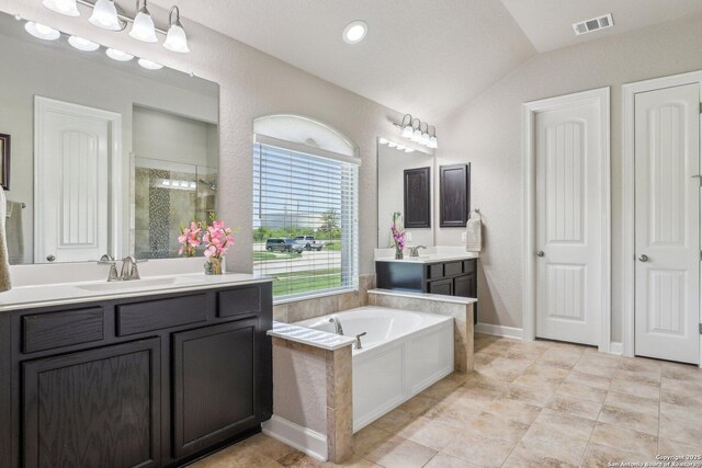 full bathroom featuring a sink, vaulted ceiling, visible vents, a shower stall, and a garden tub