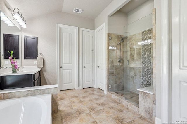 bathroom featuring a shower stall, lofted ceiling, visible vents, vanity, and a bath