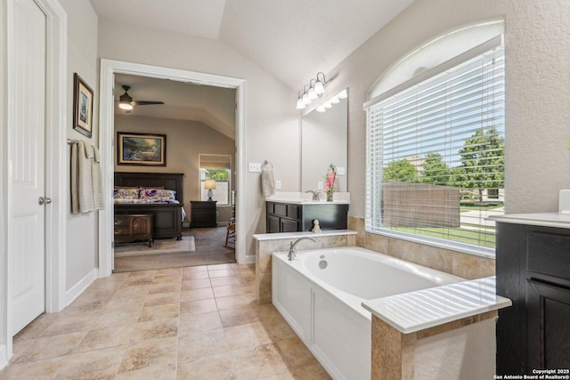 bathroom with vaulted ceiling, vanity, and plenty of natural light