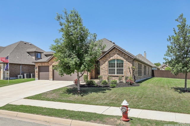 view of front facade with fence, a front lawn, an attached garage, driveway, and brick siding