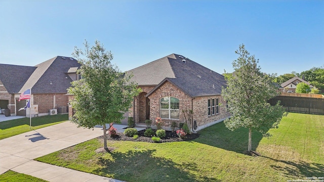 view of front of property with a front lawn, driveway, a shingled roof, fence, and brick siding