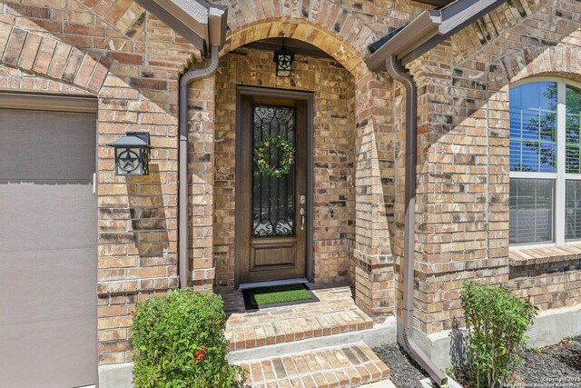 view of exterior entry with brick siding