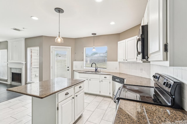 24915 Flying Arrow, San Antonio, TX 78258 - kitchen with stainless steel appliances, a sink, a kitchen island, decorative backsplash, and white cabinetry