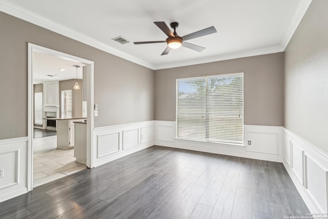 24915 Flying Arrow, San Antonio, TX 78258 - empty room featuring dark wood finished floors, wainscoting, ceiling fan, a decorative wall, and ornamental molding