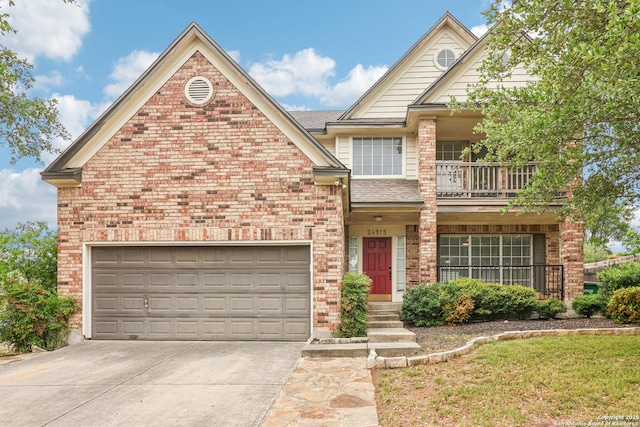 24915 Flying Arrow, San Antonio, TX 78258 - view of front of house with a balcony, driveway, a shingled roof, a garage, and brick siding