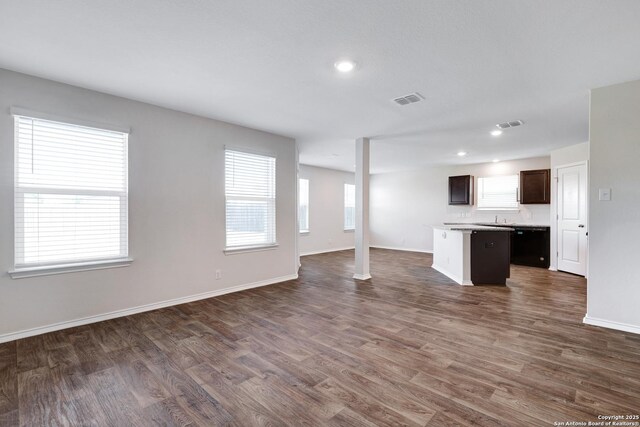 6551 Legato, San Antonio, TX 78252 - unfurnished living room with baseboards, visible vents, dark wood-type flooring, and a healthy amount of sunlight