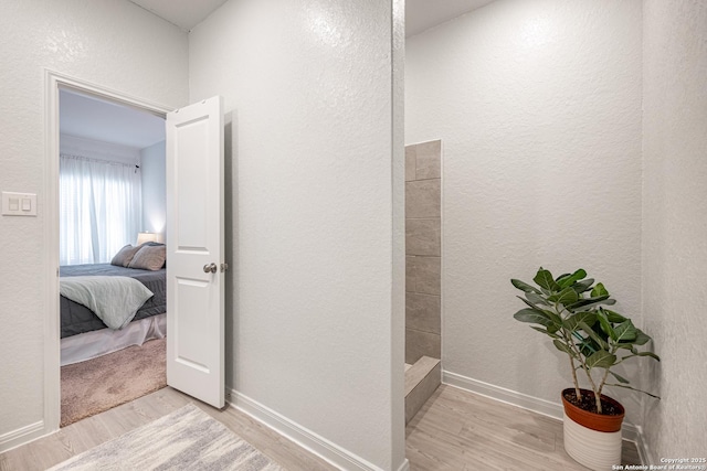 209 Wolf Crst, Seguin, TX 78155 - ensuite bathroom with wood finished floors, a tile shower, and a textured wall
