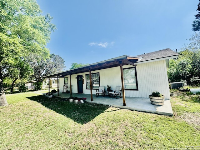 back of house with a porch, a lawn, and central AC unit