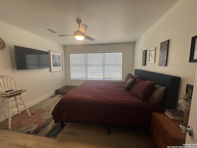 bedroom featuring visible vents, baseboards, wood finished floors, and ceiling fan
