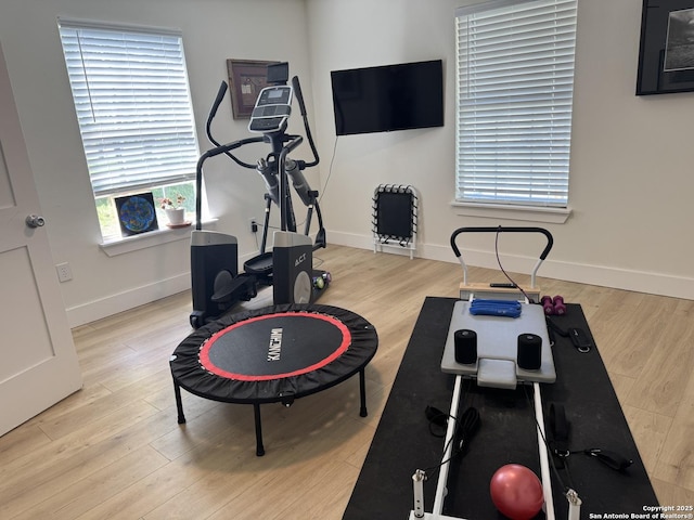 exercise room featuring wood finished floors and baseboards