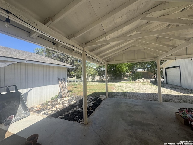 view of patio / terrace with a garage and fence