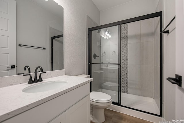 310 Vamanos, Boerne, TX 78006 - bathroom with a shower stall, toilet, a textured wall, and wood finished floors