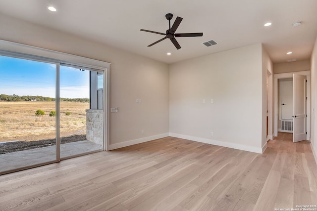 empty room with light wood finished floors, baseboards, visible vents, and ceiling fan