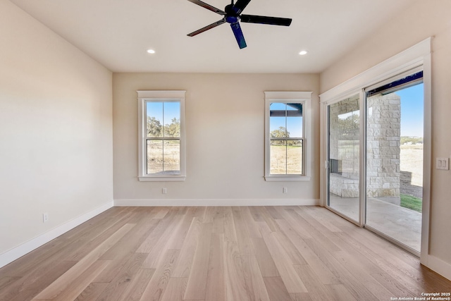 spare room featuring plenty of natural light, light wood-style floors, and ceiling fan