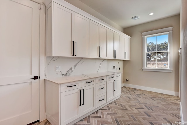 interior space featuring baseboards, visible vents, hookup for a washing machine, cabinet space, and electric dryer hookup