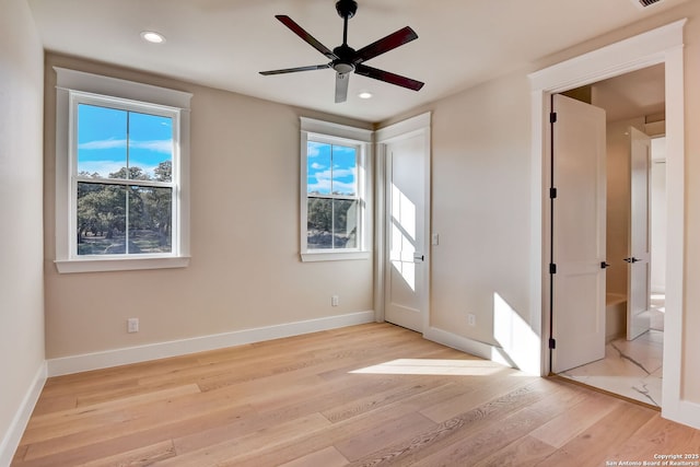 unfurnished bedroom with light wood-type flooring, baseboards, and multiple windows