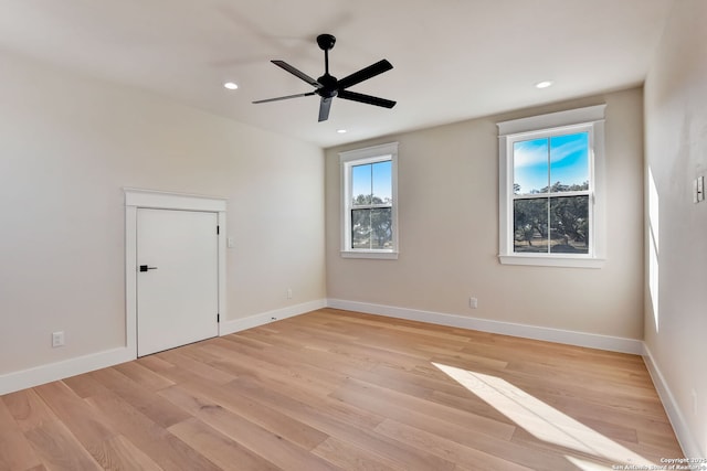 spare room featuring ceiling fan, baseboards, and light wood-style flooring