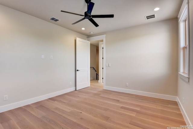 unfurnished room featuring light wood finished floors, visible vents, a ceiling fan, and baseboards