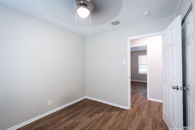 empty room with ceiling fan, baseboards, dark wood-style flooring, and visible vents