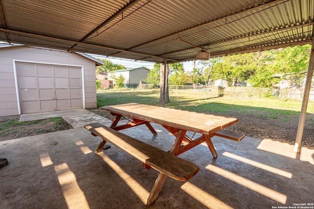 view of patio featuring fence, an outbuilding, and outdoor dining space