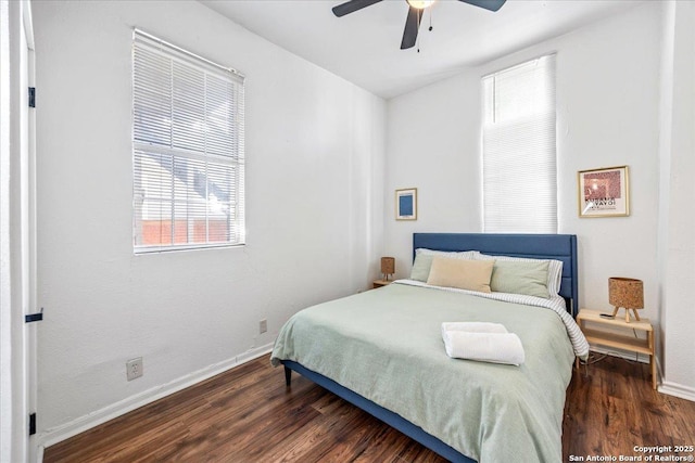 bedroom featuring wood finished floors, a ceiling fan, baseboards, and multiple windows
