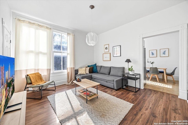 living area with baseboards and dark wood finished floors