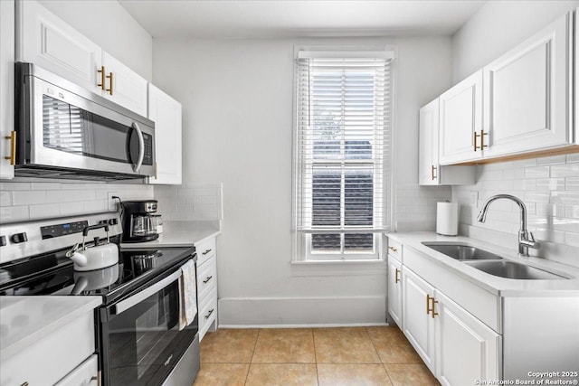 kitchen featuring light countertops, backsplash, stainless steel appliances, and a sink