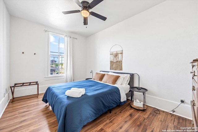 bedroom with baseboards, a ceiling fan, and wood finished floors