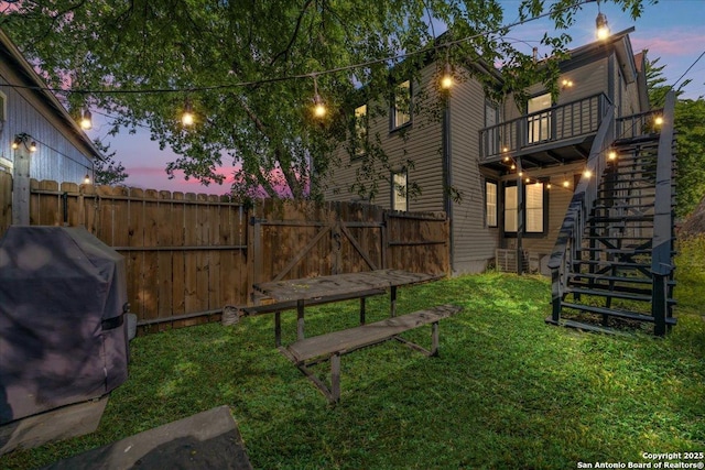 view of yard featuring a gate, fence private yard, stairs, and a deck