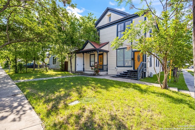 victorian house featuring a porch and a front lawn