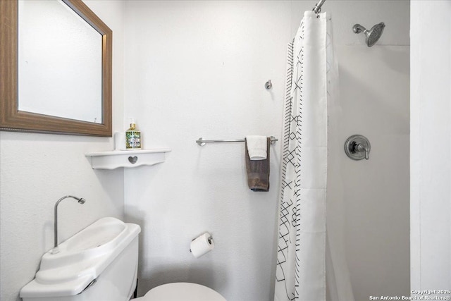 bathroom featuring curtained shower and toilet