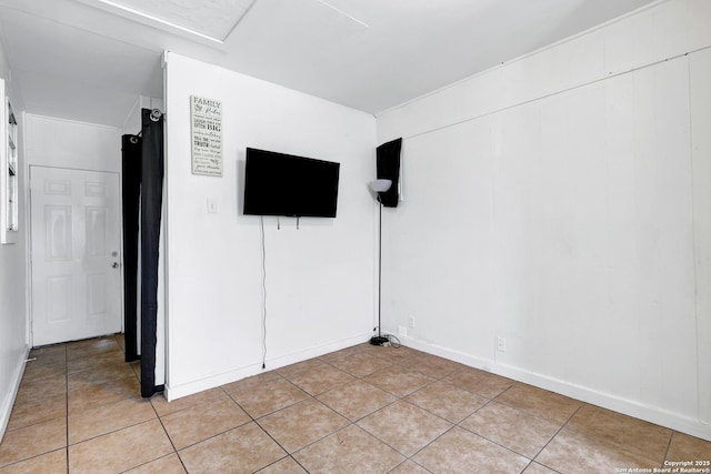unfurnished room featuring light tile patterned flooring and baseboards