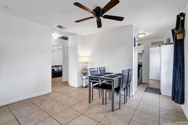 dining room featuring baseboards, a ceiling fan, visible vents, and light tile patterned floors