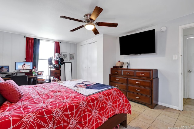 bedroom featuring a closet, a ceiling fan, baseboards, and light tile patterned floors