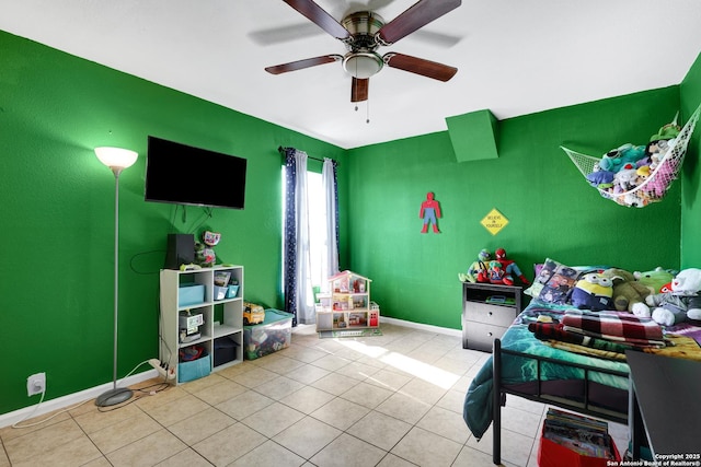 tiled bedroom featuring a ceiling fan, baseboards, and an accent wall