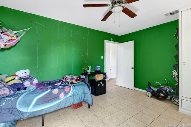 bedroom featuring a ceiling fan, visible vents, and light tile patterned floors