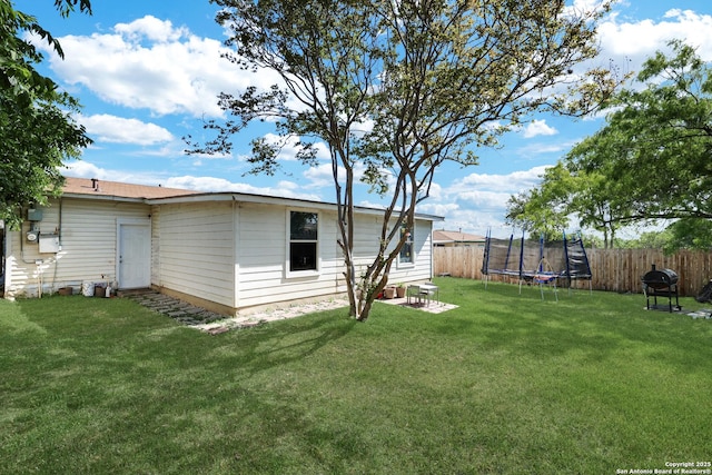 view of yard featuring a fenced backyard and a trampoline