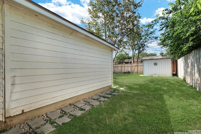 view of yard with a fenced backyard, an outdoor structure, and a storage shed