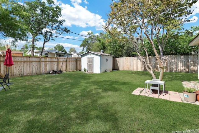 view of yard with an outdoor structure, a storage unit, a patio area, and a fenced backyard