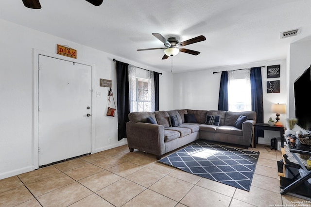 living area with light tile patterned flooring, visible vents, and ceiling fan