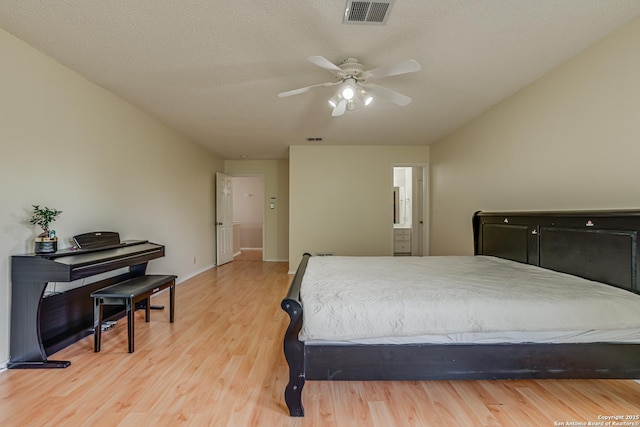 bedroom featuring light wood-style floors, visible vents, and a ceiling fan