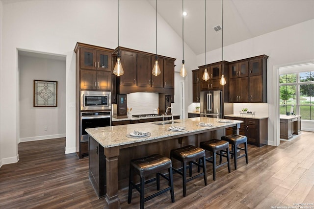110 Madrone Trl, Boerne, TX 78006 - kitchen featuring dark wood finished floors, stainless steel appliances, backsplash, dark brown cabinetry, and high vaulted ceiling